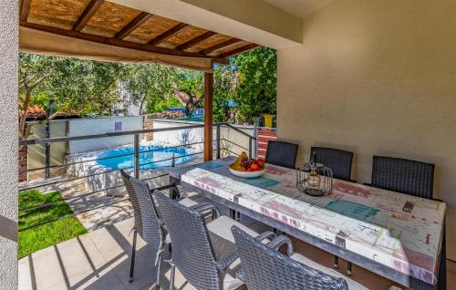 Un patio con mesa y sillas y una piscina. en Stunning Home In Medulin, en Medulin