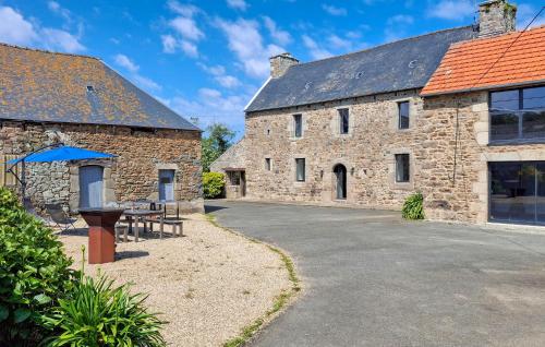 un gran edificio de piedra con una mesa de picnic delante de él en Ravissante Maison Bretonne, en Pleumeur-Gautier