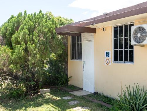a house with a door and a tree at Mona Studio suite in Kingston