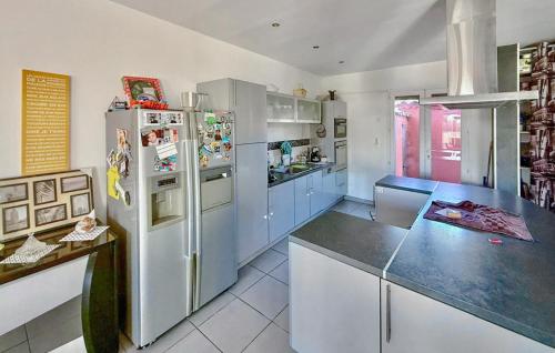 La cuisine est équipée de placards bleus et d'un réfrigérateur. dans l'établissement 4 Bedroom Beautiful Home In Rognac, à Rognac