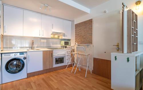 a kitchen with white cabinets and a washer at Stunning Apartment In Albuñol With Wifi in Albuñol