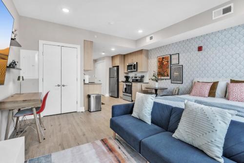 a living room with a bed and a blue couch at Floor To Ceiling Windows- Bridge Views - Studio in Philadelphia