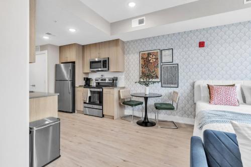 a kitchen and a bedroom with a bed and a table at Floor To Ceiling Windows- Bridge Views - Studio in Philadelphia