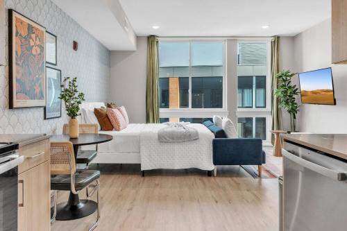 a bedroom with a bed and a table in a room at Floor To Ceiling Windows- Bridge Views - Studio in Philadelphia