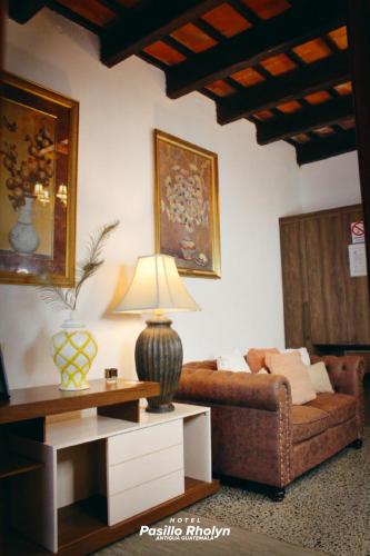 a living room with a couch and a table with a lamp at Hotel Rholyn Pura Vida!! in Antigua Guatemala
