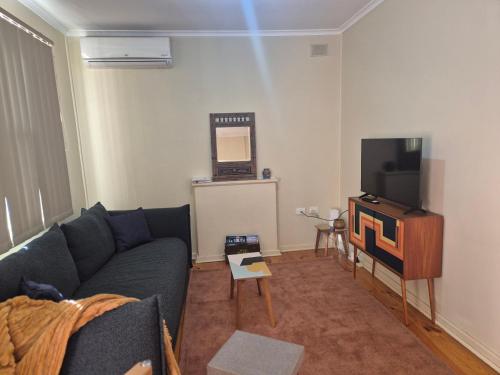 a living room with a couch and a tv at 3 Bedroom Home in Whyalla