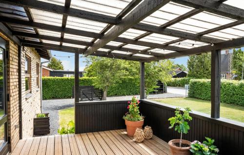 a pergola over a deck with potted plants at Amazing Home In Viborg With Wifi in Viborg