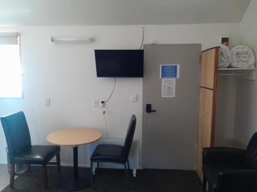 a room with a table and chairs and a door at Wellington 747 Motel in Wellington