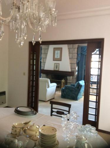 a dining room with a table and a chandelier at Casa Dos Oliva in Alcobaça