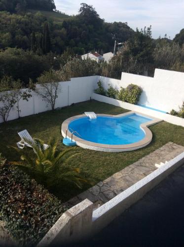 a swimming pool in the yard of a house at Casa Dos Oliva in Alcobaça
