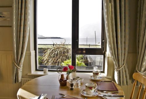 a table with a view of the ocean from a window at Teach Cruachan Large-Group Holiday Home in Dooagh