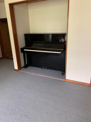 a black piano sitting inside of a room at 旅宿景雅 in Yamanakako