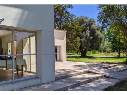 a white house with a window and a tree at Atuel hole inclusive in San Rafael