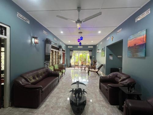 a living room with leather couches and a table at 288 Jeyamany Villa in Jaffna