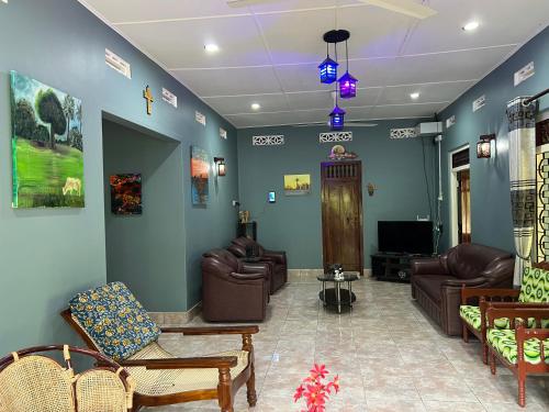 a living room with couches and chairs and a tv at 288 Jeyamany Villa in Jaffna