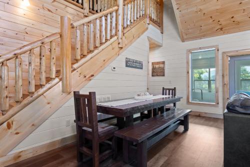 a dining room with a wooden table and stairs at Smoky Bear Splash Top Rated Private Pool Cabin with Hot Tub, Mtn Views, Arcade Games, Excellent Location in Pigeon Forge