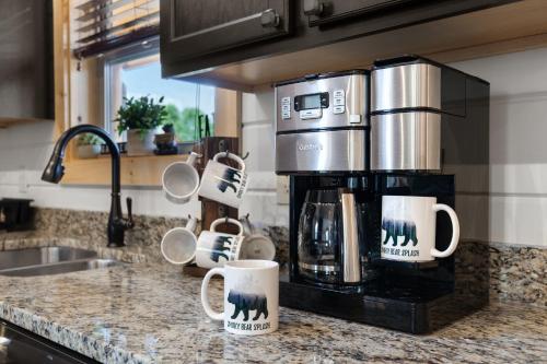 a kitchen counter with a coffee maker and coffee mugs at Smoky Bear Splash Top Rated Private Pool Cabin with Hot Tub, Mtn Views, Arcade Games, Excellent Location in Pigeon Forge