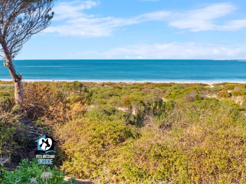 a sign on a beach with the ocean in the background at Absolute Beachfront 3BR 2BA Home w/ Beach Track in McCracken