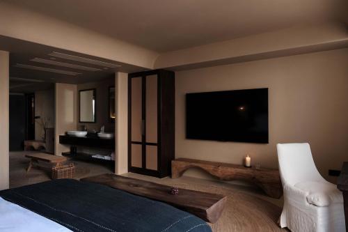 a bedroom with a bed and a flat screen tv at Dali Warm Dwellingt Hotel in Dali Ancient Town
