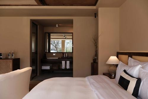 a bedroom with a large white bed and a window at Dali Warm Dwellingt Hotel in Dali Ancient Town