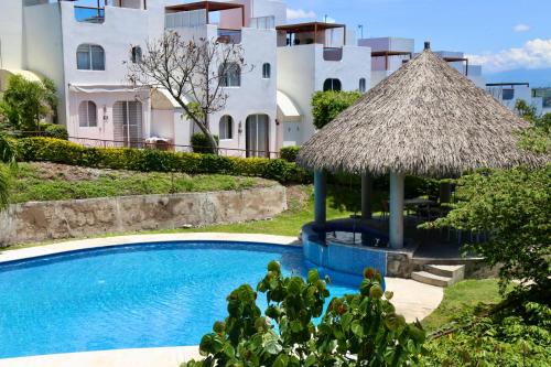 un complexe avec une piscine et un parasol dans l'établissement Casa Colibri Teques, à Tequesquitengo