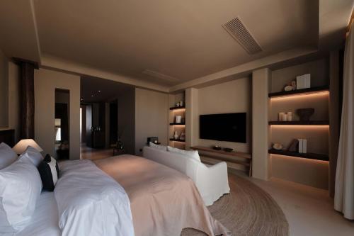 a bedroom with a large bed and a flat screen tv at Dali Warm Dwellingt Hotel in Dali Ancient Town