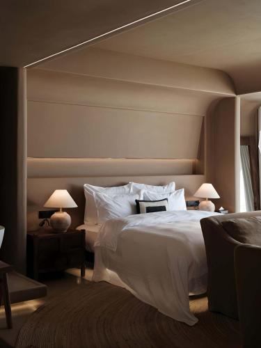 a bedroom with a large white bed with two lamps at Dali Warm Dwellingt Hotel in Dali Ancient Town