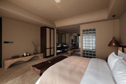 a bedroom with a large white bed and a bathroom at Dali Warm Dwellingt Hotel in Dali Ancient Town