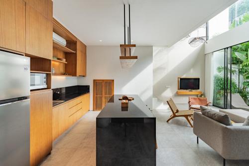 a kitchen and living room with a black counter top at Botanika Estate Private Pool Villa in Canggu