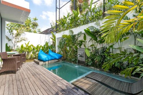 a swimming pool in a garden with plants at Botanika Estate Private Pool Villa in Canggu