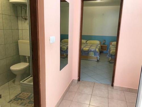 łazienka z toaletą oraz pokój z łóżkiem w obiekcie Apartments Isabella - Family Friendly w mieście Kustići