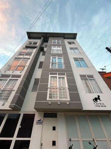 a tall building with many windows on it at Tayra Living Suites in Mocoa