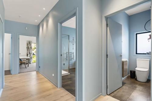 un couloir avec une porte menant à une salle de bains. dans l'établissement Island Views - Waihi Beach Holiday Home, à Waihi Beach