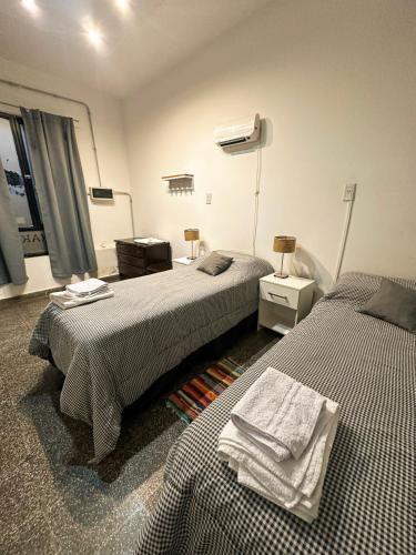 a bedroom with two beds and a window and two towels at CAFAYATE Departamento céntrico in Cafayate