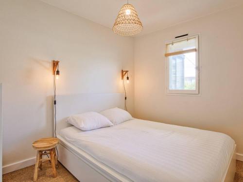 une chambre avec un lit blanc et une fenêtre dans l'établissement Charmant deux pièces rénové avec balcon et parking à Cabourg - FR-1-788-75, à Cabourg