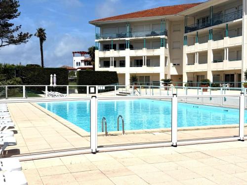 une clôture autour d'une piscine en face d'un bâtiment dans l'établissement Studio face au golf avec terrasse et parking - FR-1-4-702, à Ciboure