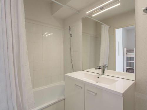 une salle de bain blanche avec un lavabo et un miroir dans l'établissement Studio face au golf avec terrasse et parking - FR-1-4-702, à Ciboure