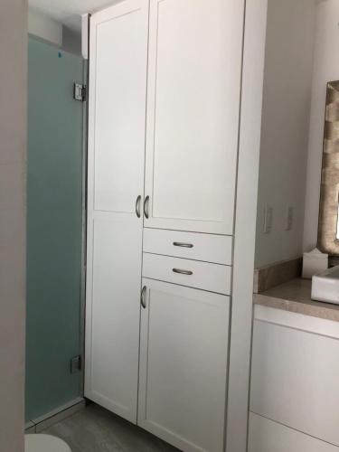 a white cabinet in a kitchen with white cabinets at The Residences by Morgan in Cabo San Lucas