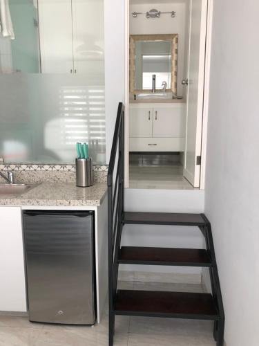 a kitchen with a staircase leading to a sink at The Residences by Morgan in Cabo San Lucas