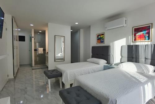 a hotel room with two beds and a bathroom at The Residences by Morgan in Cabo San Lucas
