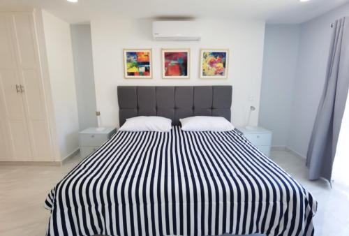 a black and white bed in a white room at The Residences by Morgan in Cabo San Lucas