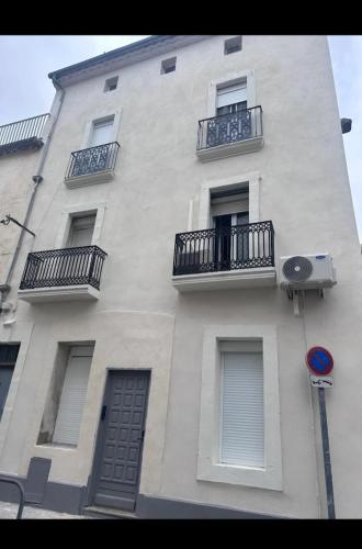 a tall white building with balconies on the side of it at Suite GOLD by L Amaryllis I Jacuzzi & Sauna privé I Centre Béziers Arrivée autonome in Béziers