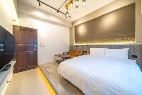 a bedroom with a large white bed and a wooden door at 寵物友善-無門禁24小時進出-水母漂民宿-免費停車 in Toucheng