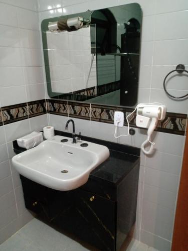a bathroom with a sink and a mirror at Suíte no Morumbi in Sao Paulo