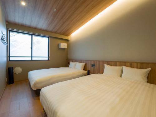 a hotel room with two beds and a window at Rakuten STAY VILLA Hakone Togendai in Hakone