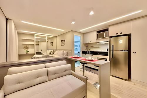 a kitchen and living room with a couch and a refrigerator at *ExtraOdiNáriO, Super Confort. Lazer com piscina. in Curitiba