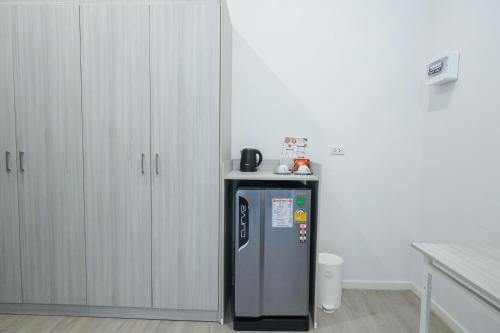 a kitchen with a refrigerator with a table on top at GRAND PA Hotel&Resort Lamphun Chiang Mai in Lamphun