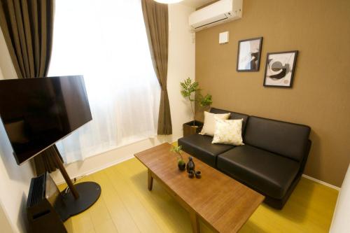 a living room with a black couch and a table at アイマーレ天空橋 in Tokyo