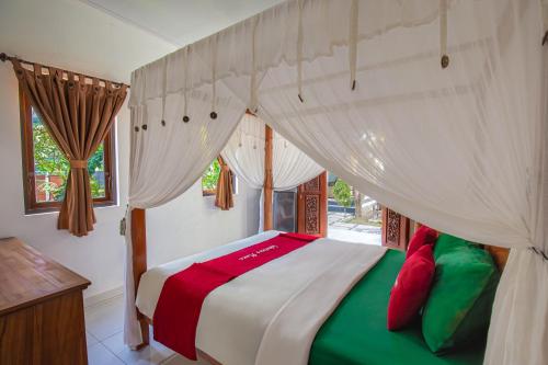 a bedroom with a bed with red and green pillows at Sekarinis Place in Amed