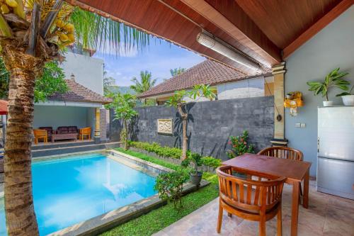 a patio with a table and chairs next to a swimming pool at Sekarinis Place in Amed